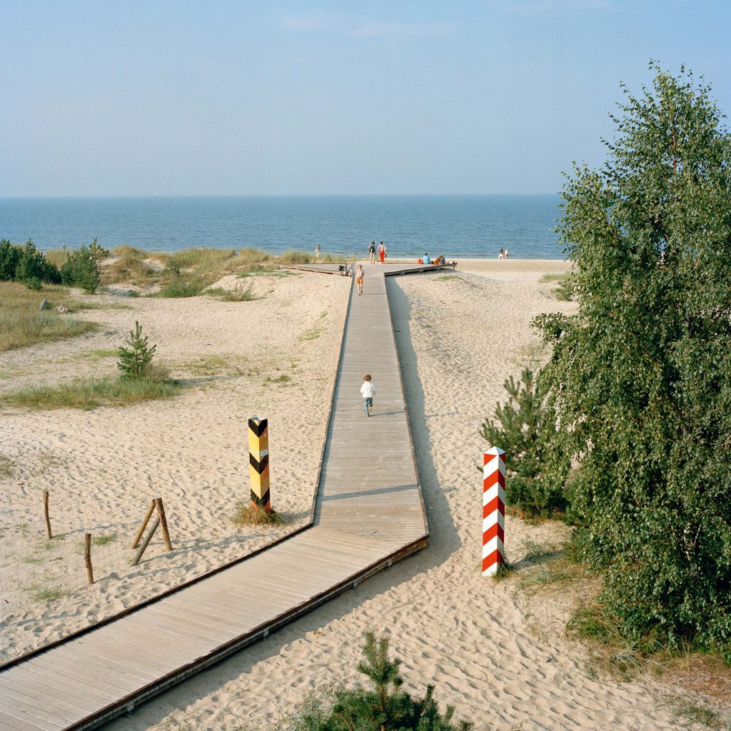 Chemin en planches sur une plage marquant la frontière