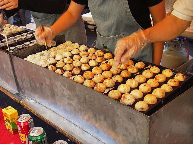 gros plan sur le plan de cuisson ou s'alignent les takoyaki