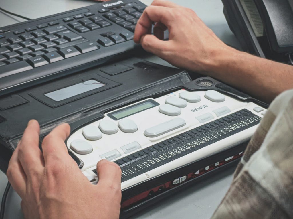 Un homme utilisant un lecteur d'écran braille