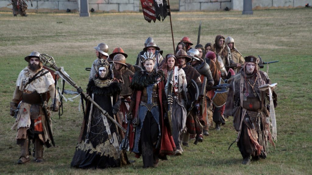 Une troupe de joeur·ses costumés en reine, magiciens et guerriers