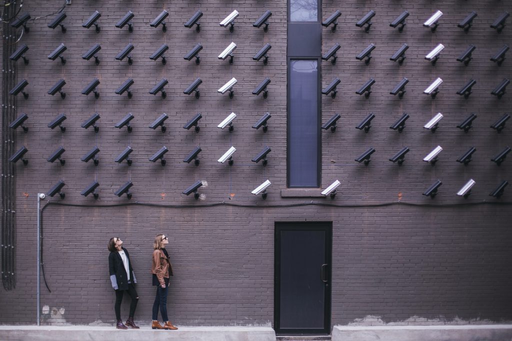 Deux femmes sous un mur rempli de caméras de videosurveillance