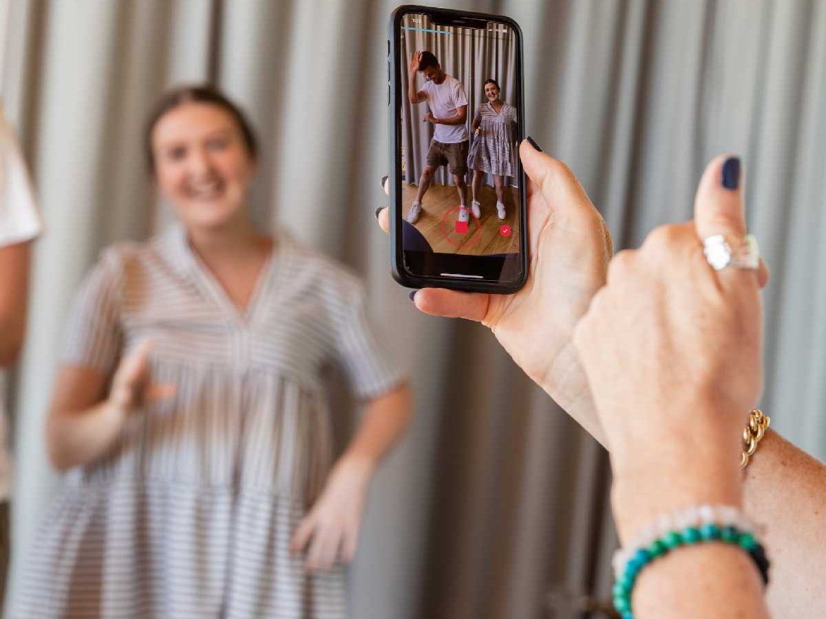 Couple dansant pour une femme qui les filme avec son smartphone