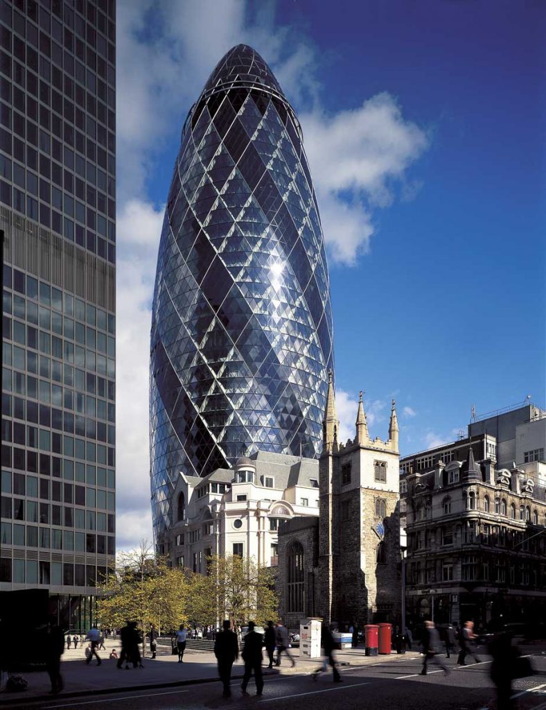 La tour du 30 St Mary Axe conçue par l'agence Foster + Partners, avec une vieille église en pierre au premier plan