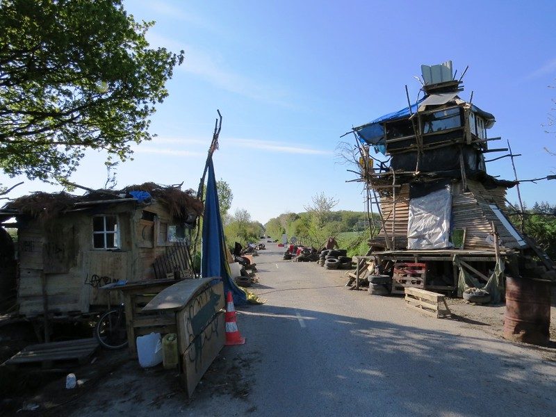 Des batiments artisanaux en bois disposés sur une ZAD