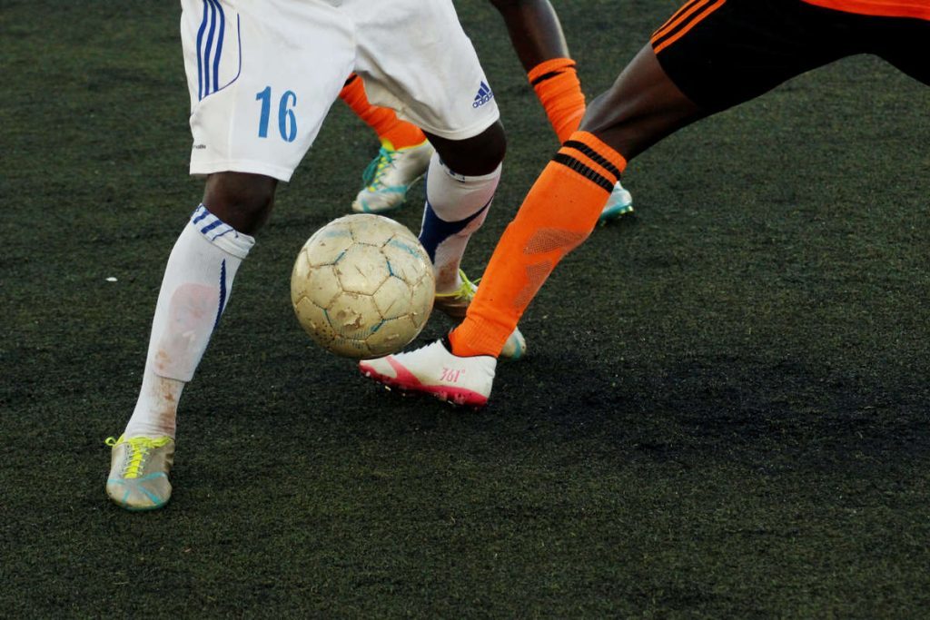 duel de football, centré sur le ballons entre les pieds des deux joueurs