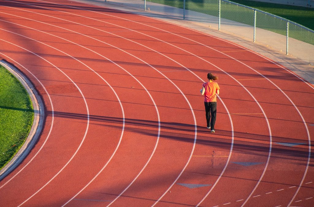 femme courant seule sur une piste d'athlétisme