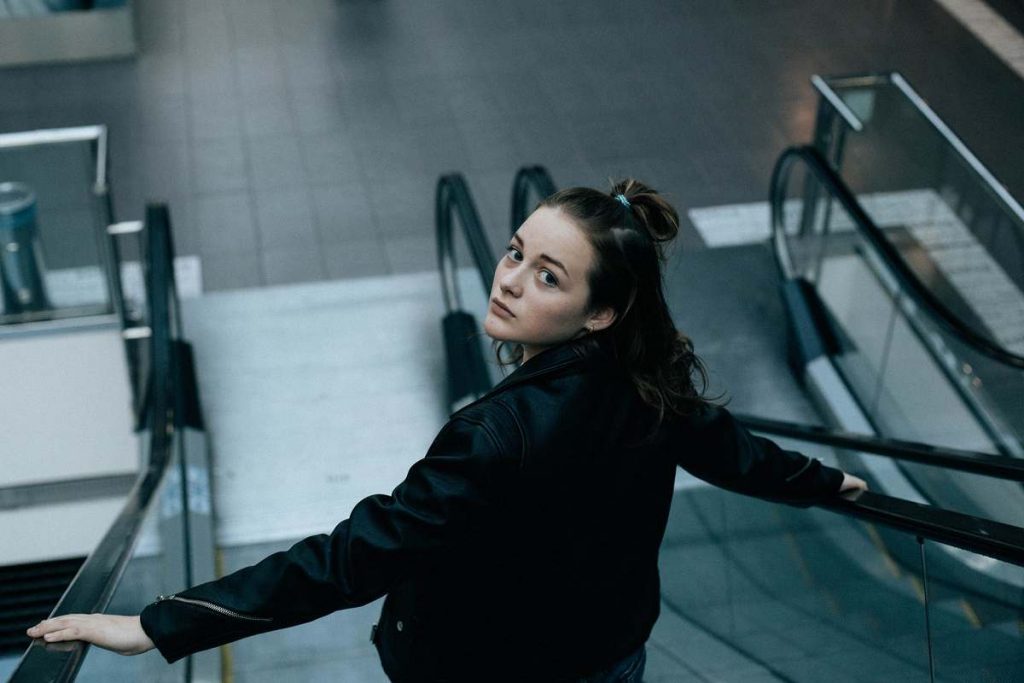 femme dans un escalator regardant derrière elle