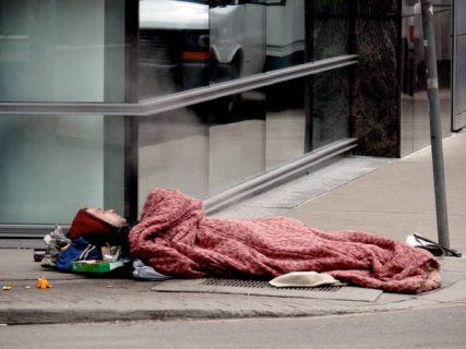 Photo d'un SDF couché, à même le sol