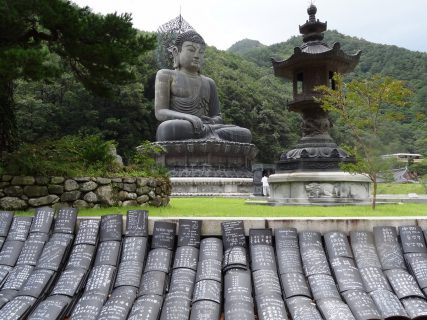 Un gigantesque bouddah sur fond de montagnes