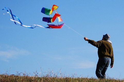 photographie d'un homme tenant un cerf-volant