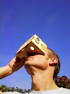 homme regardant dans un casque virtuel en carton