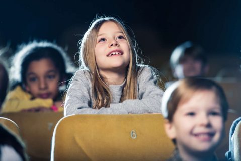 fillette au cinéma regardant l'écran