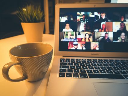 Un écran connecté sur Zoom, une tasse posée à côté.