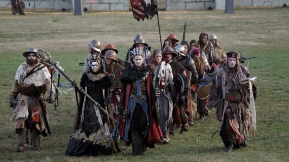 Une troupe de joueur·ses costumés en reine, magiciens et guerriers