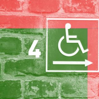 Une pancarte signalant un accès handicapé sur un vieux mur