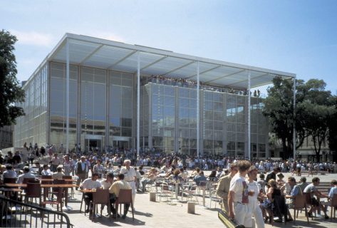 Le Carré d'art, cube de verre et de métal clair avec un auvent tenant sur de fines colonnes. Une foule est installée en terrasse, autour de tables de café.