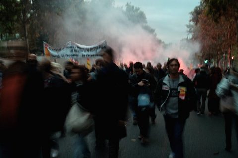 Des manifestants défilent sous une banderole dans une rue