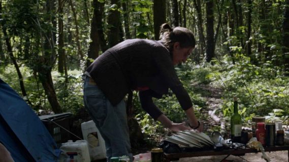 une femme faisant sa vaisselle dans le Bois de Vincennes.